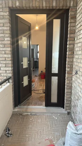 Portoncino scuro aperto, con il laterale vetrato