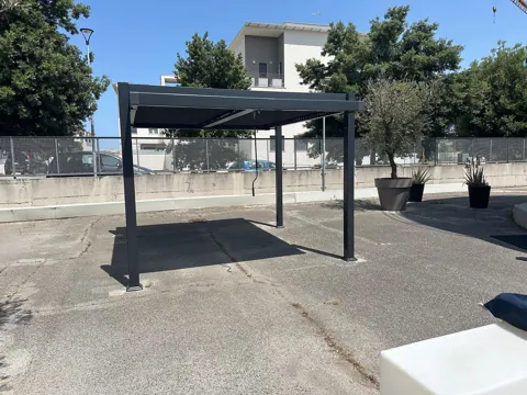Pergola bioclimatica antracite in un piazzale